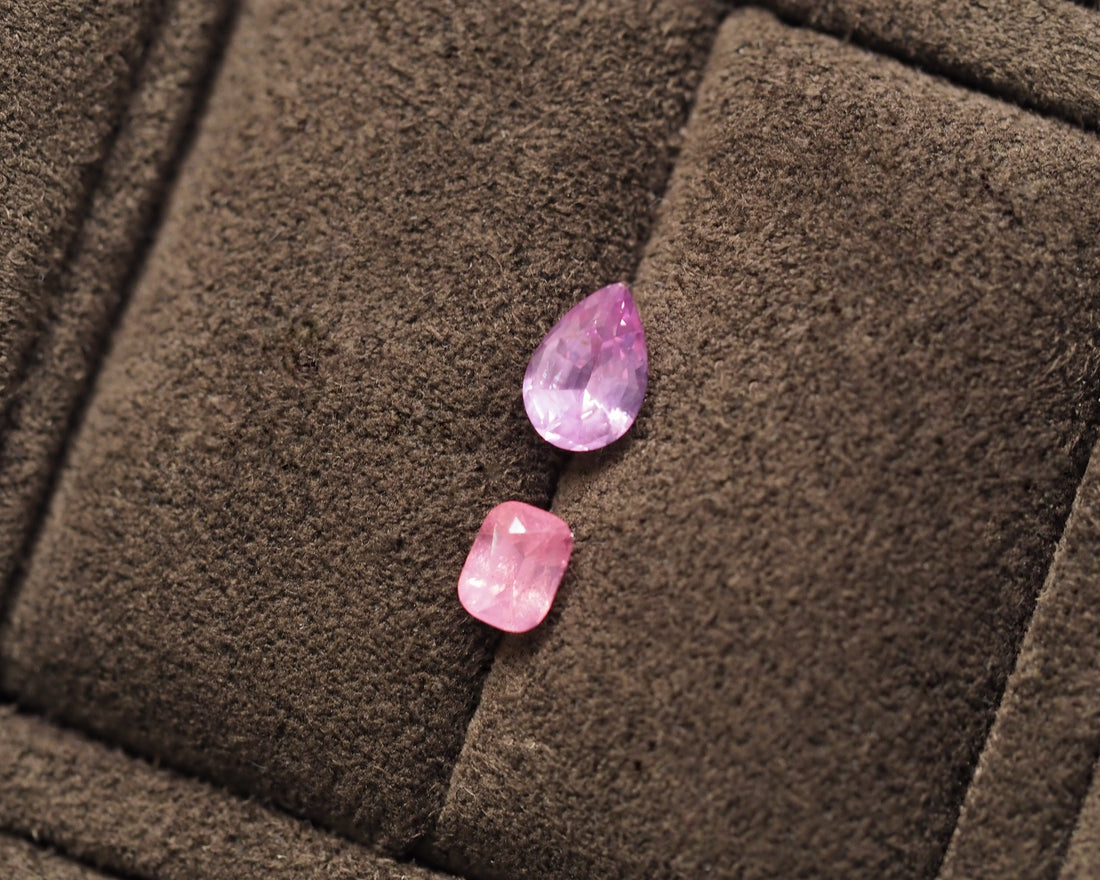 Two milky pink spinels placed on top of a brown velvet background