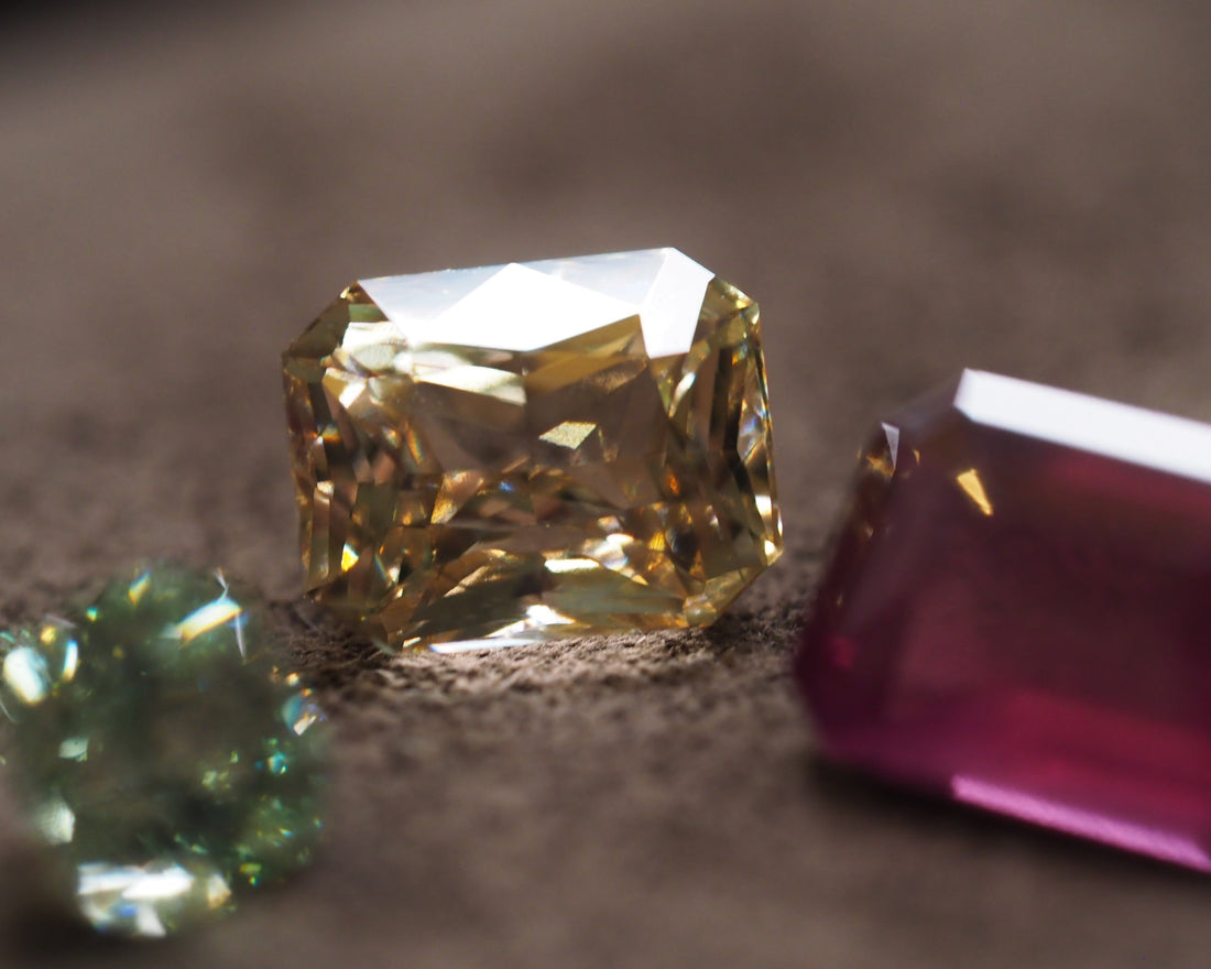 Three different colour garnets placed in front of a brown velvet background