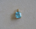 Carolyn Asscher Aquamarine pendant in front of a beige background