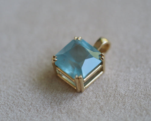 Carolyn Asscher Aquamarine pendant in front of a beige background