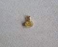 Gold pendant with a yellow gemstone on a light gray background