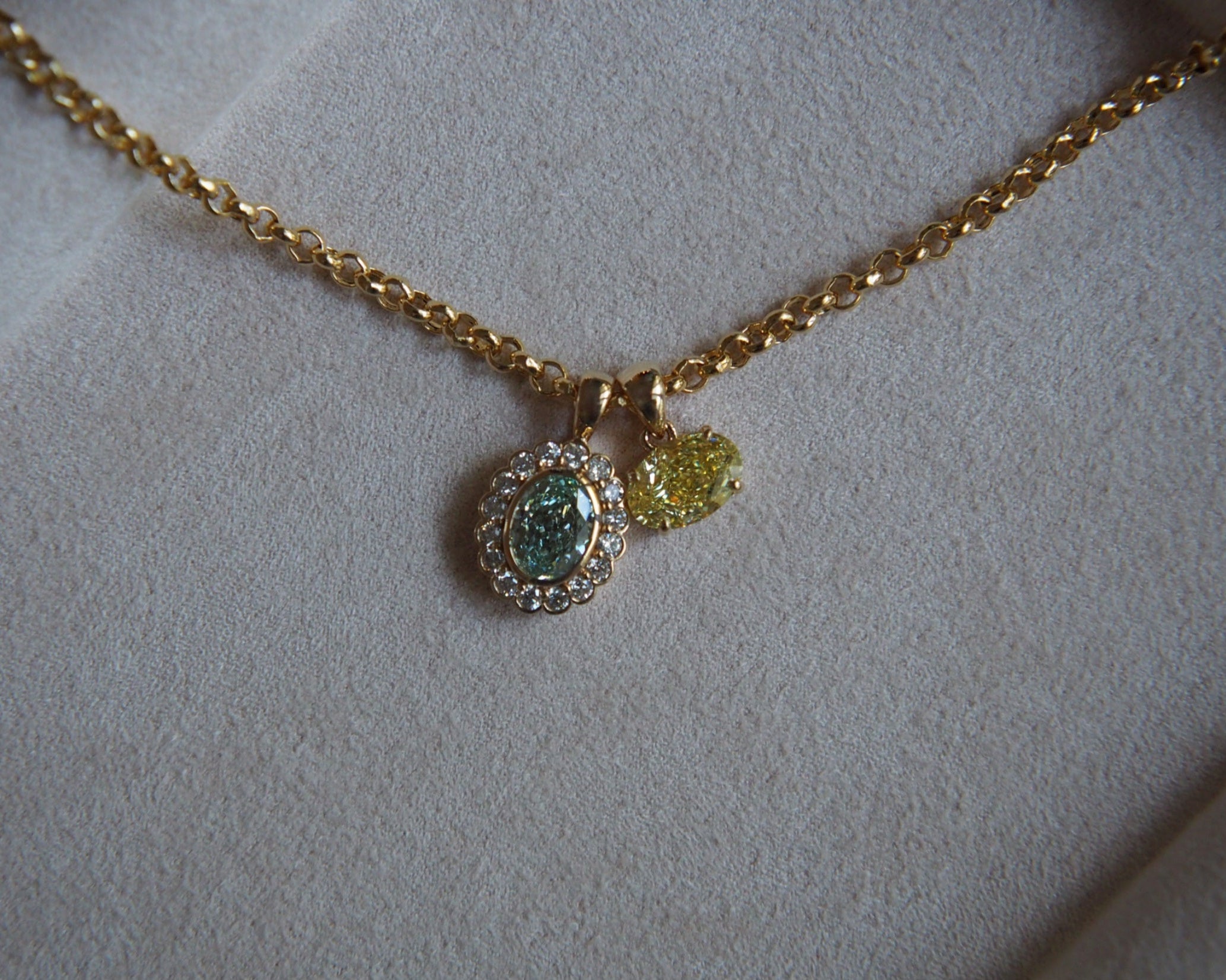Gold necklace with two pendants on a light gray background